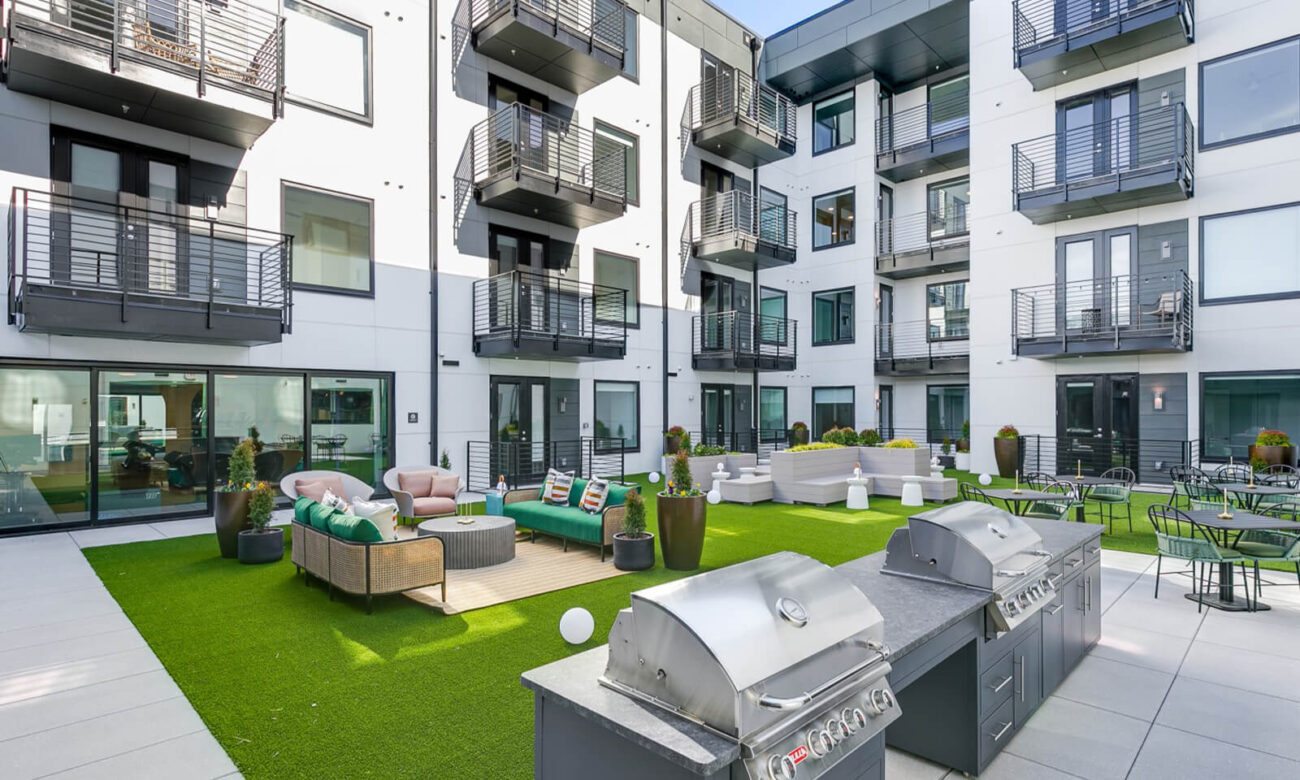 Courtyard at GEM with artificial grass flooring, lots of seating options, and two grills.
