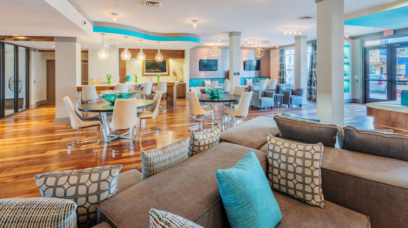 Streets of Greenbrier indoor common room decorated with logs of teal and white.